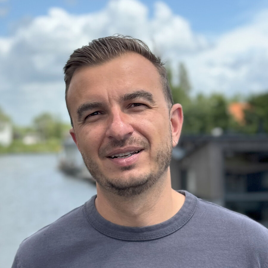 Photo of me standing and smiling on a bridge in Amsterdam Noord.